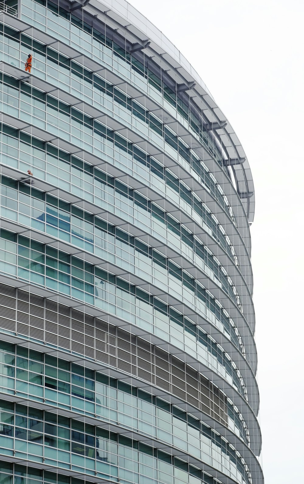 curved glass building under white sky