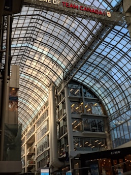 Exterior view of a large shopping mall with waterproofing work in progress.