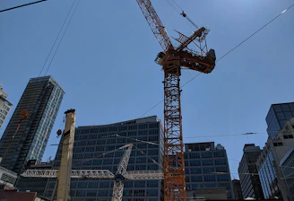 Modern construction site with cranes and workers collaborating under clear sky.