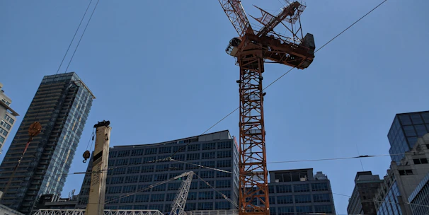 Modern construction site with cranes and workers collaborating under clear sky.