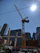 A construction crane lifting heavy materials on a bright clear day in an urban site.