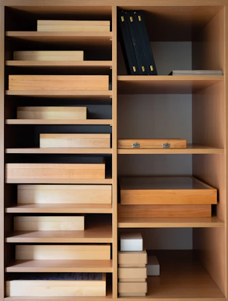 A neatly organized shelf filled with various sizes of sturdy storage boxes from cajanova.