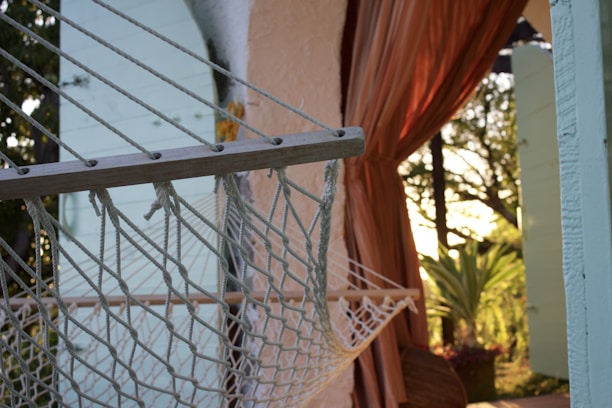 Handwoven cotton hammock hanging outdoors in natural light.