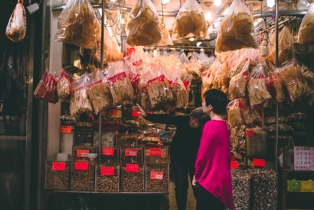 street photography of woman standing in front of store facade, Hong Kong Street Market