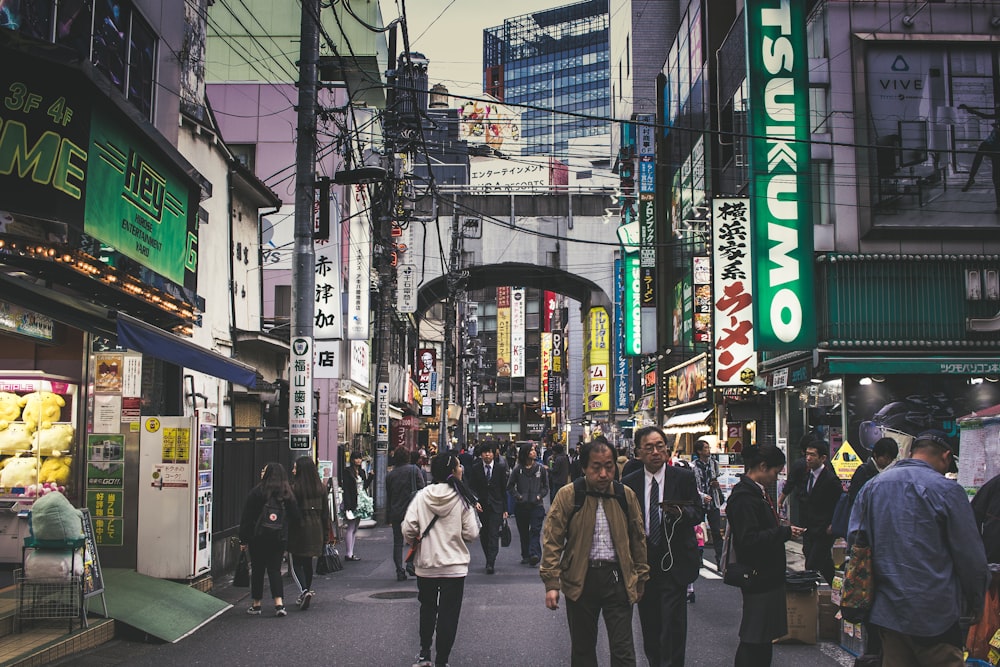 people walking beside gray building during daytime