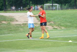 two women fist bumping on field