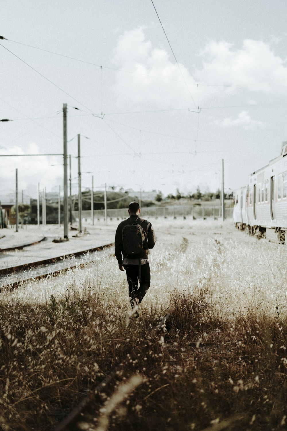 man walking into grass field during daytime