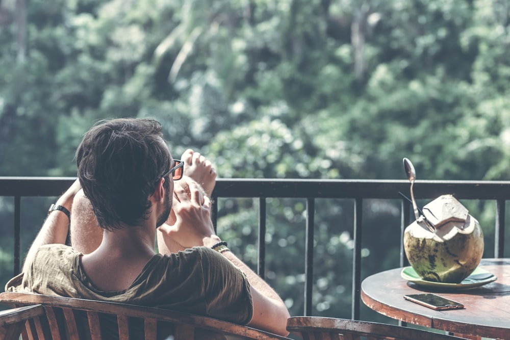 beating tech addiction. Man sitting on armchair near table with opened coconut