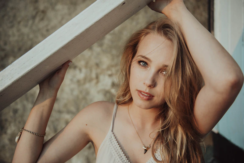 Mujer sensual apoyada en metal brillante