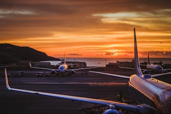 three airplane parked on road during golden hour