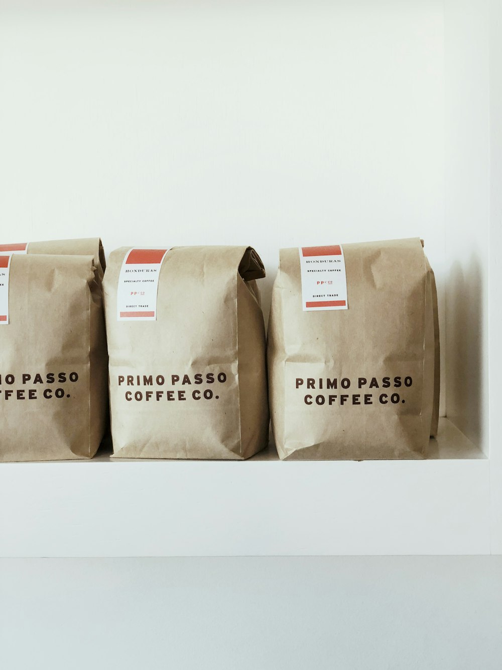 three brown Primo Passo Coffee co packs