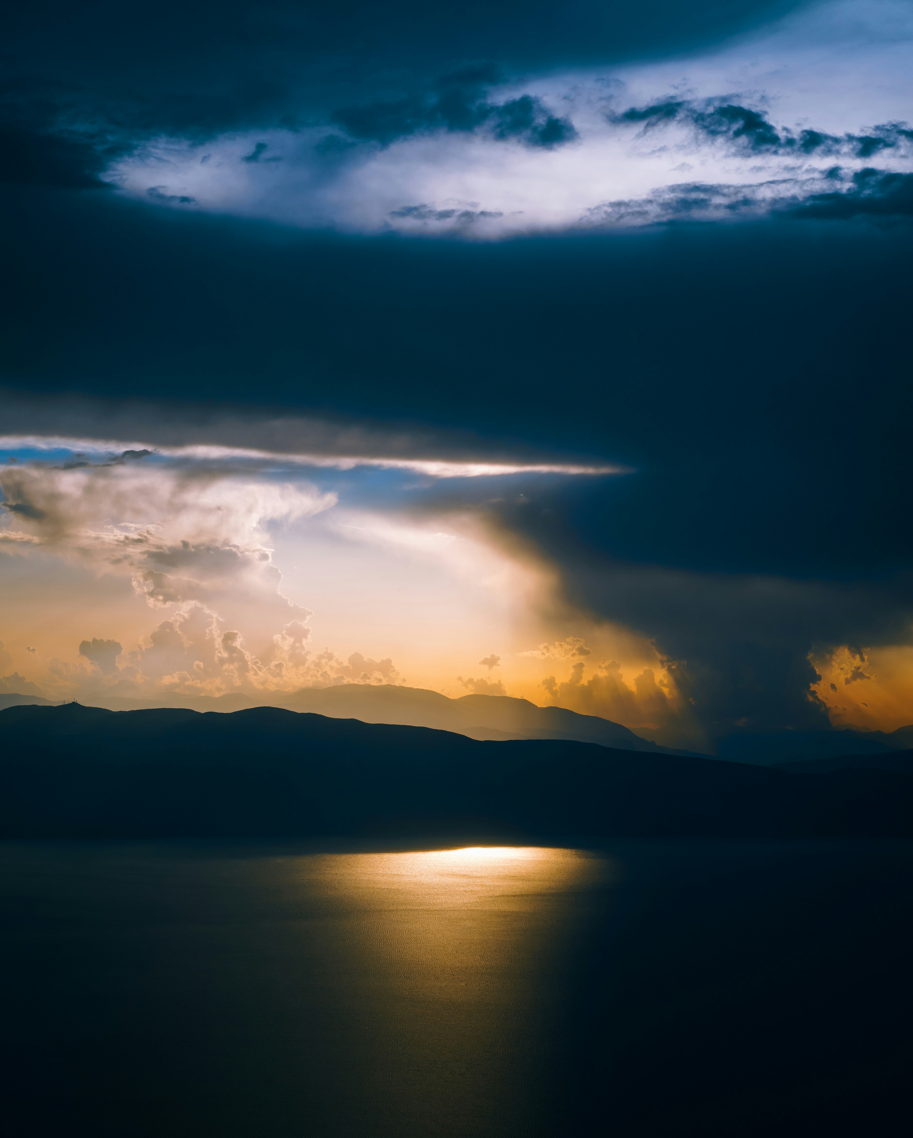 silhouette of mountain and sky near body of water