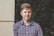 man standing beside wall winking