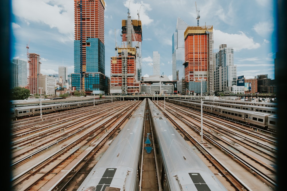 Ferrocarril del tren cerca del edificio bajo el cielo azul y las nubes blancas durante el día