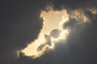 Storm clouds parting to reveal sunlight, symbolizing hope after conflict