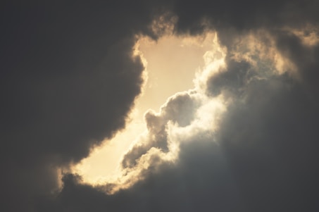 Storm clouds parting to reveal sunlight, symbolizing hope after conflict