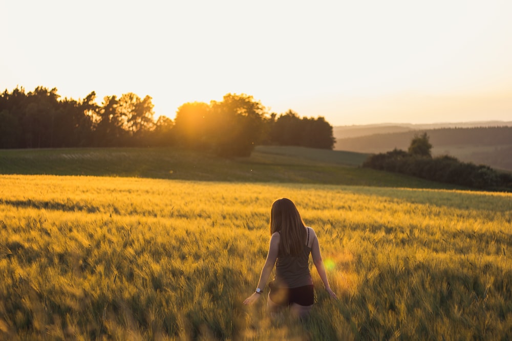 Mujer caminando en el campo de hierba durante el día