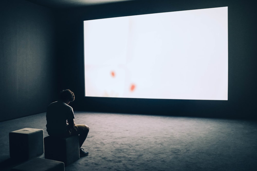 homme assis dans l’écran de projection devant