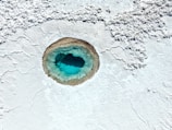 a blue hole in the white sand of a beach
