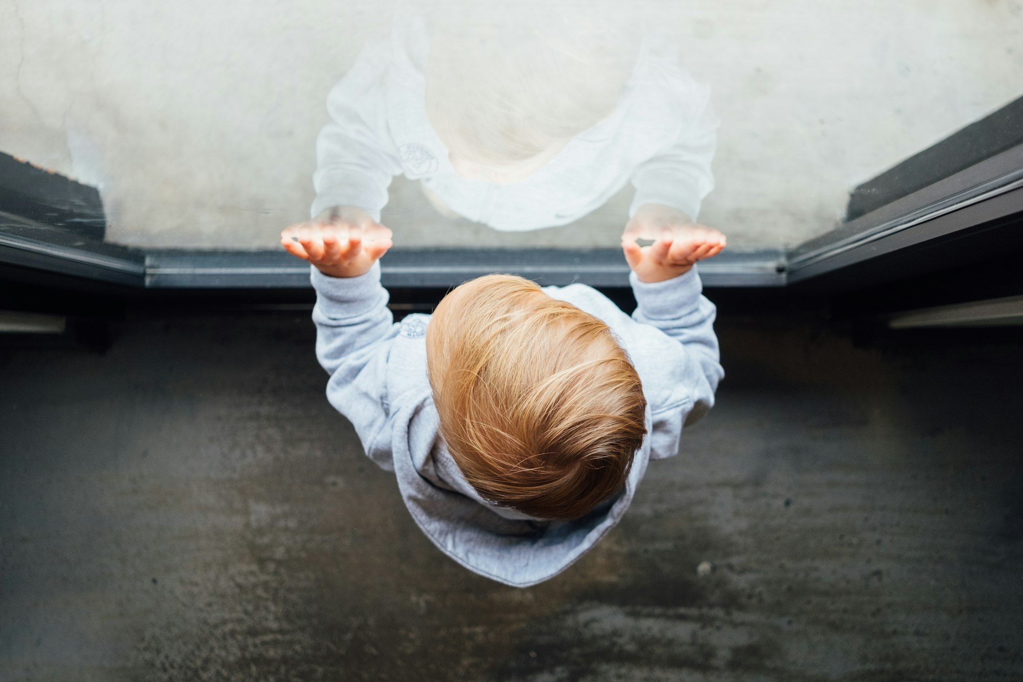 Bird's eye view of a baby behind a glass window.