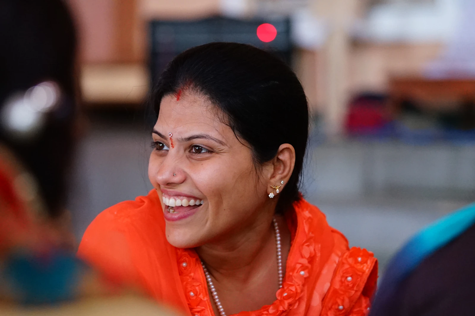 Portrait of a woman in a red shirt smiling warmly