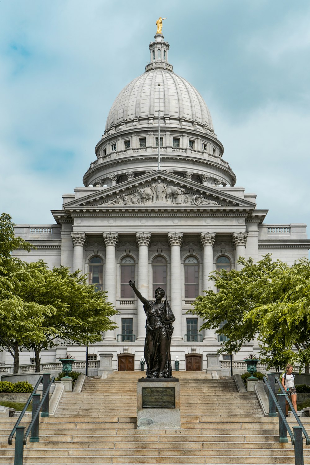 Homem montando estátua do cavalo perto do edifício de concreto branco durante o dia