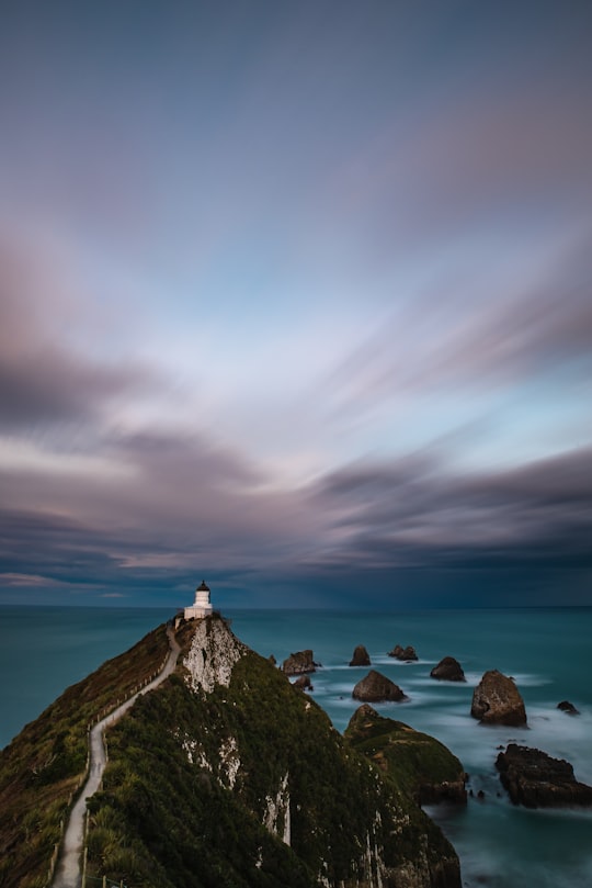 lighthouse on top of mountain peak in Nugget Point Light House New Zealand