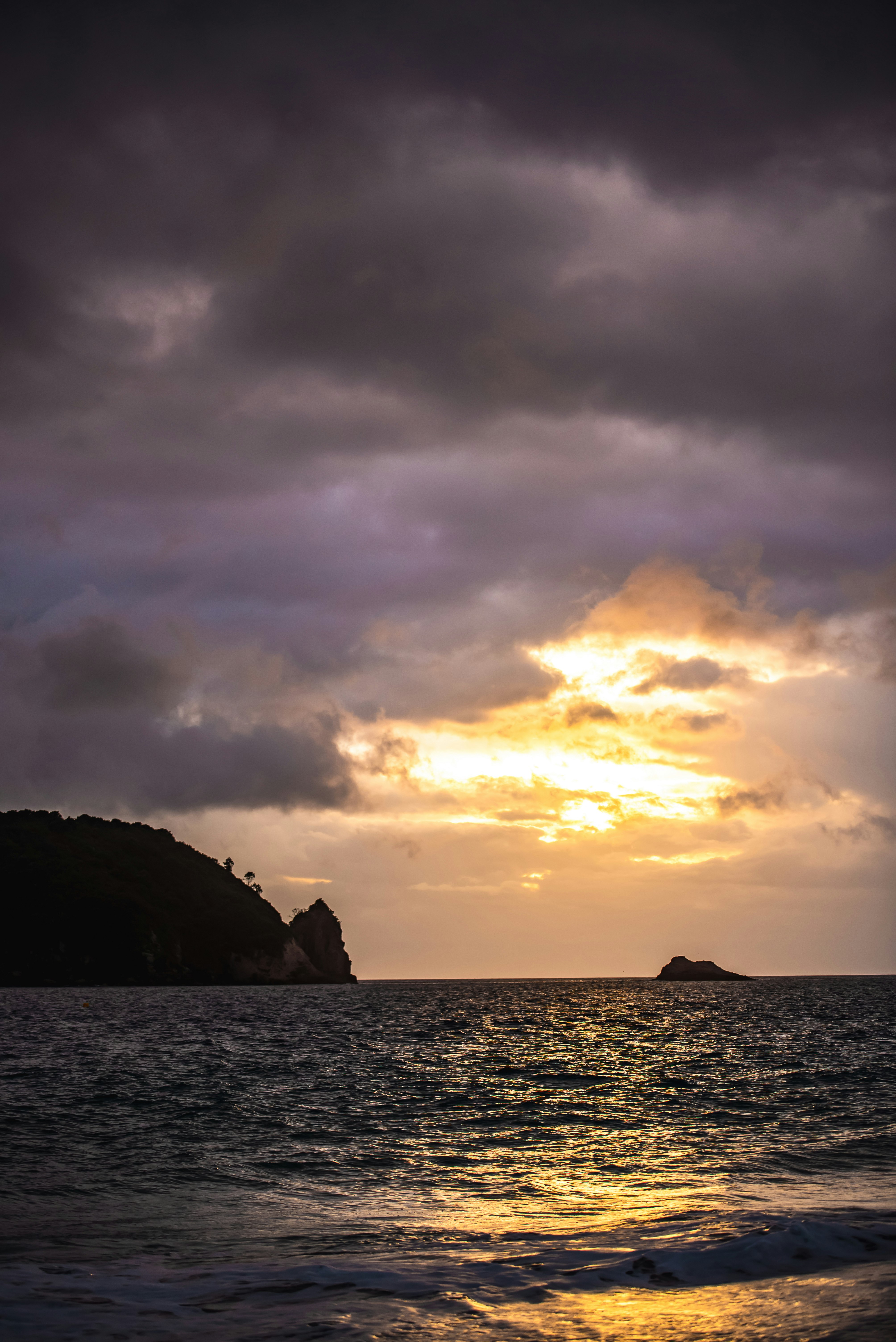 silhouette of island during orange sunset