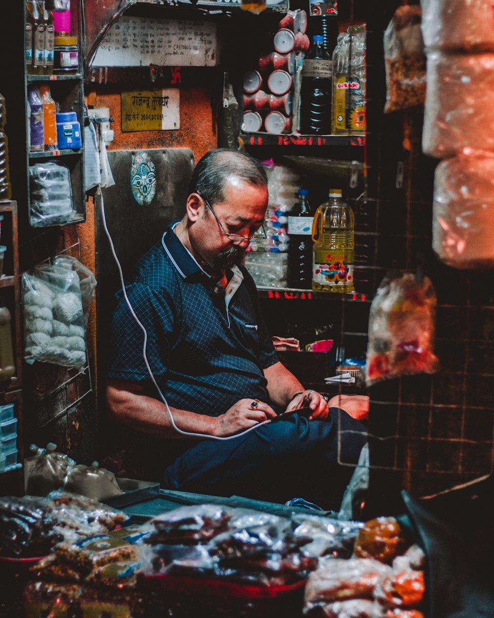 man in blue polo shirt sitting inside brown room