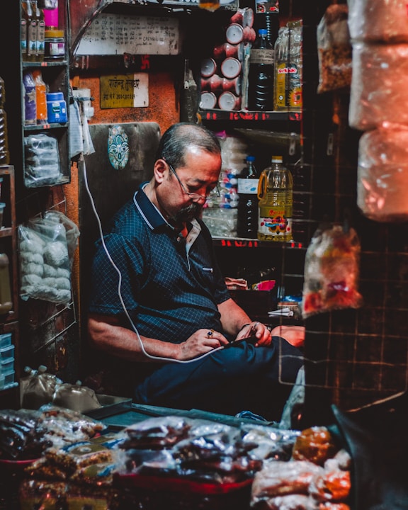 man in blue polo shirt sitting inside brown room- Thamel market