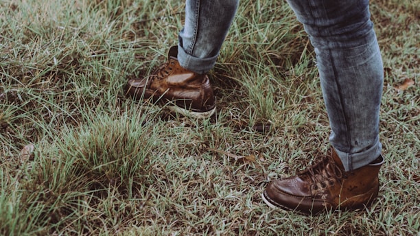 Close-up of durable gardening boots on a grassy path.