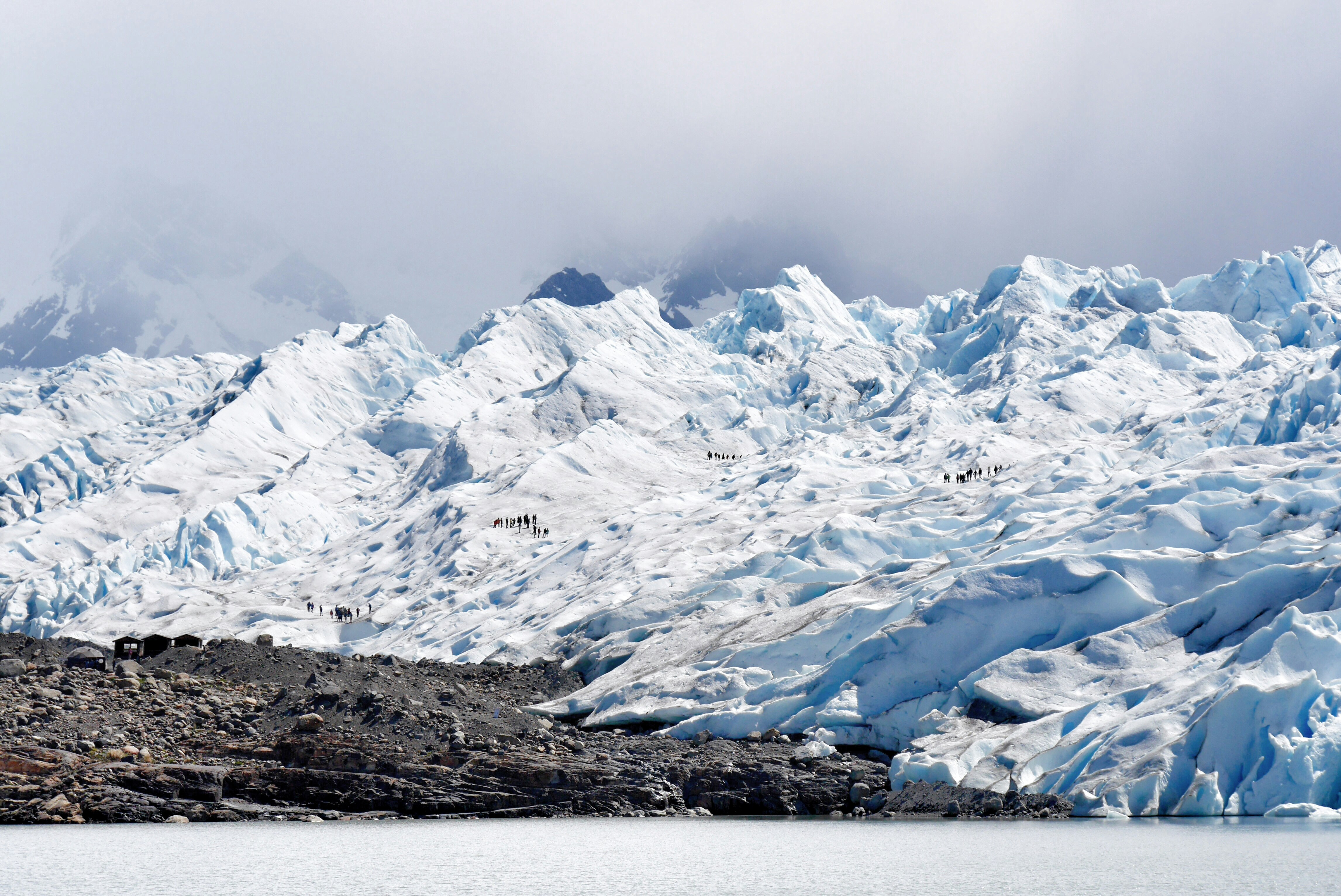 body of water with background of mountain covered with snow