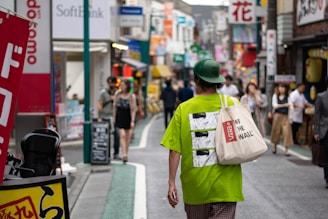 A vibrant city street scene with a person wearing a stylish hoodie and tote bag from Expresion Design and Custom.