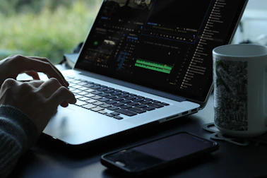 A serene workspace with minimalist design elements and a large screen showing a cinematic video edit in progress.