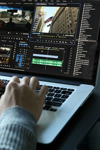 Freelancer taking notes during a video call with a client on a laptop