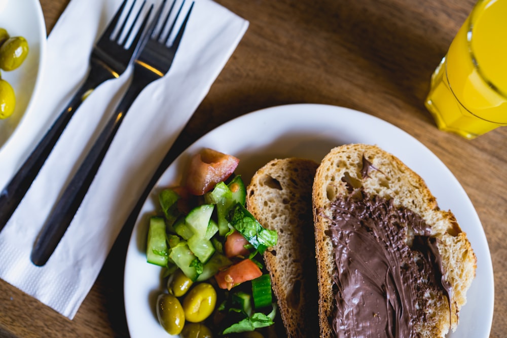 sliced bread with green vegetable on white ceramic plate