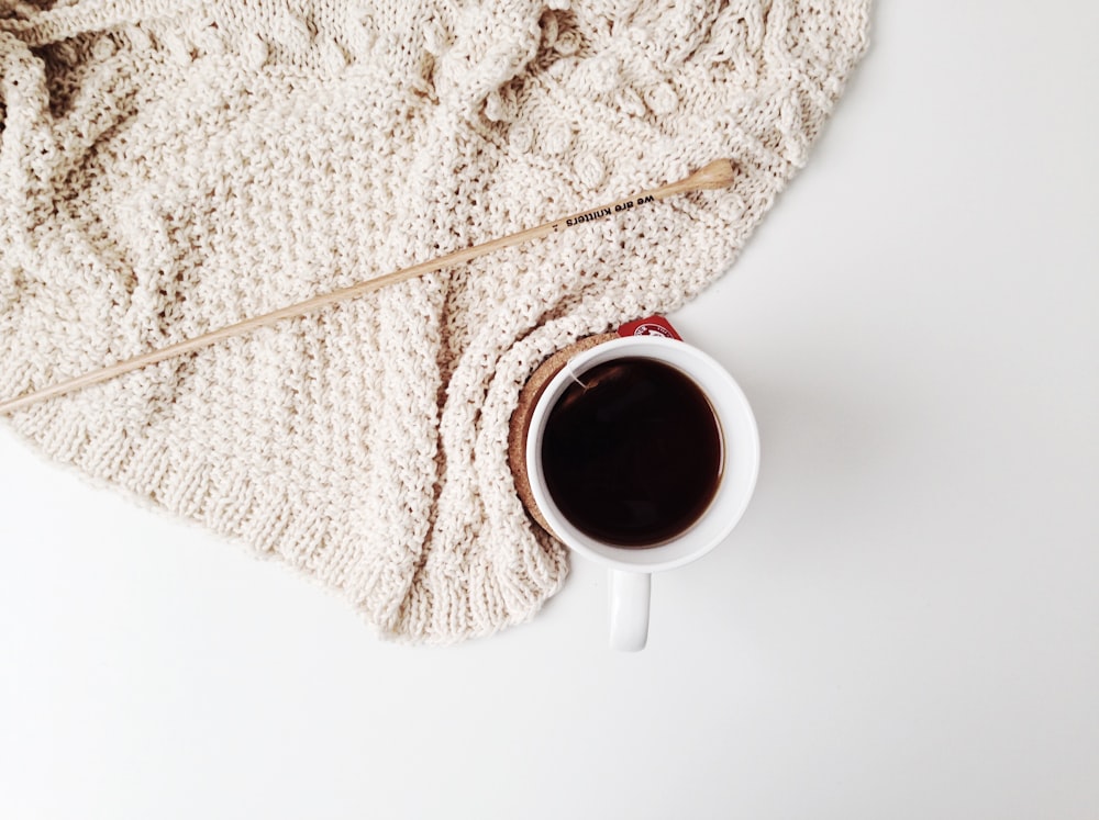 red ceramic mug on white surface