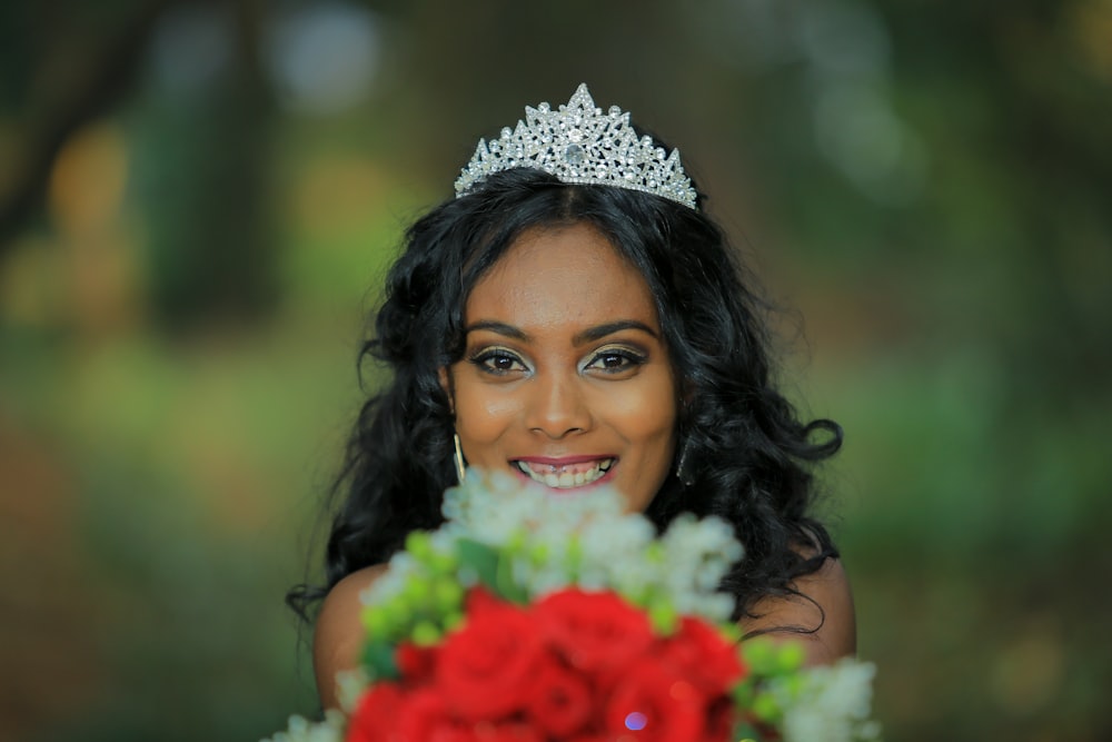 mulher vestindo tiara segurando buquê de flores