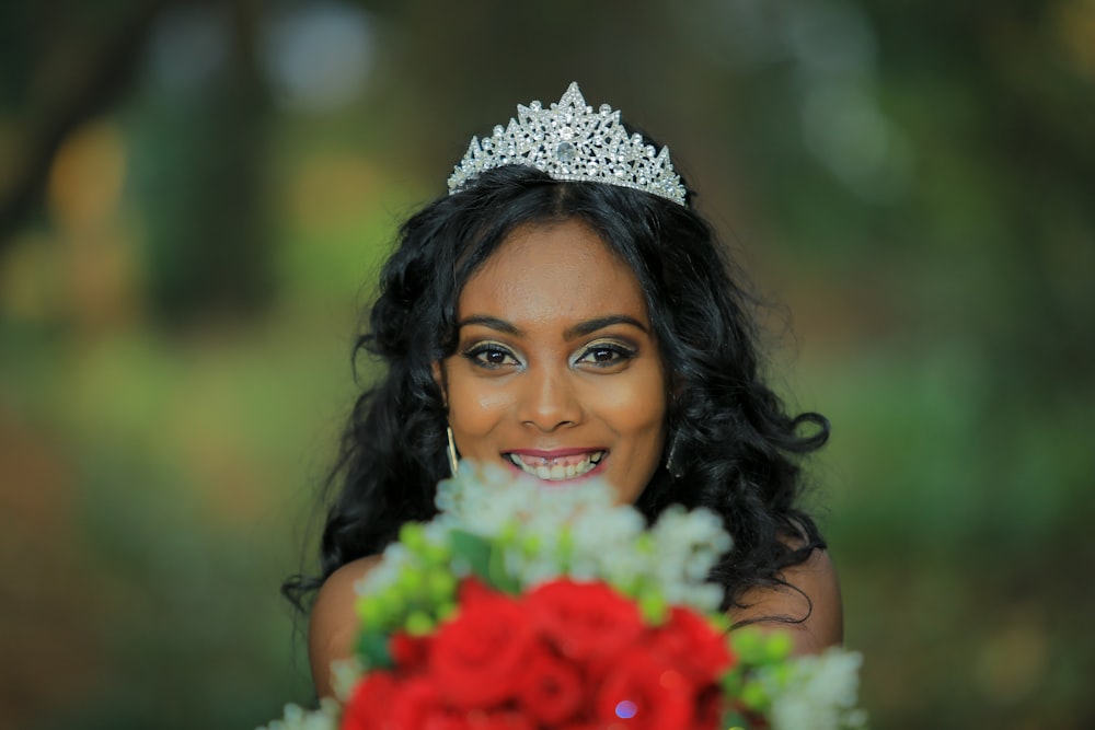 woman wearing tiara holding flower bouquet