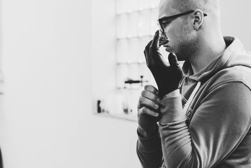 grayscale photo of man wearing glove