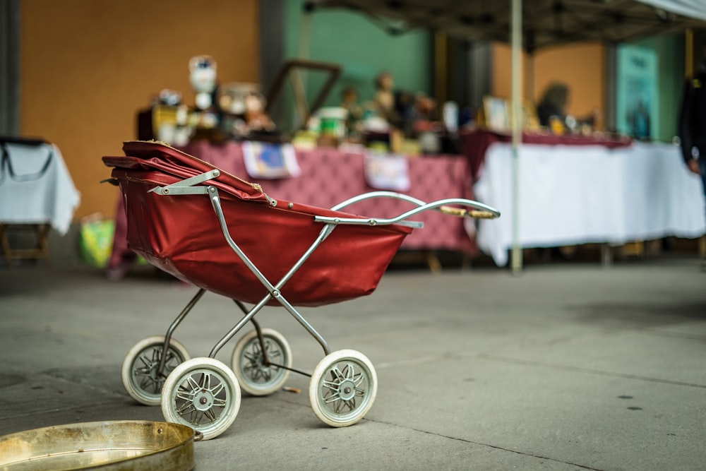 selective focus photography of red bassinet stroller