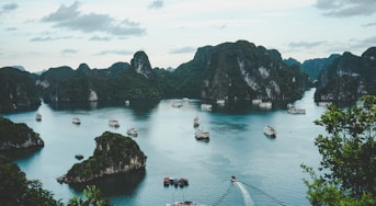 high-angle photography of boats on water near hill during daytime