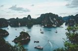 high-angle photography of boats on water near hill during daytime