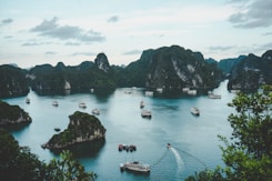 high-angle photography of boats on water near hill during daytime