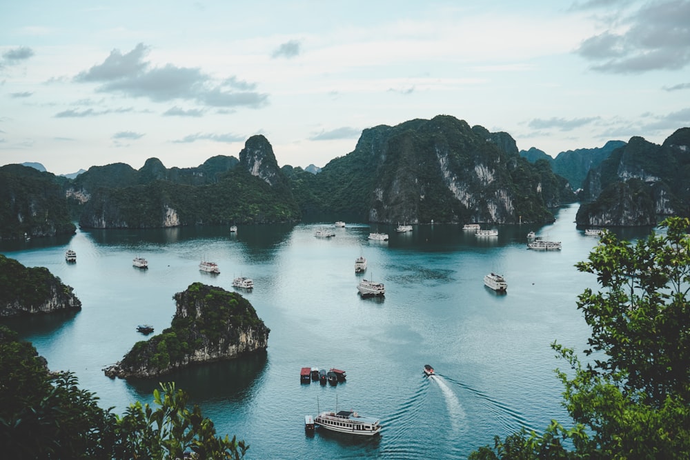 high-angle photography of boats on water near hill during daytime