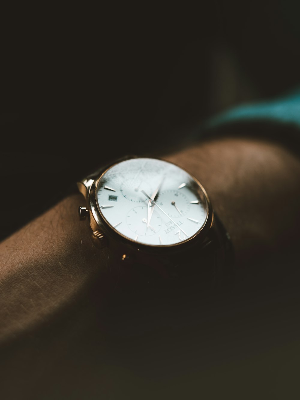 persona che indossa un orologio cronografo bianco