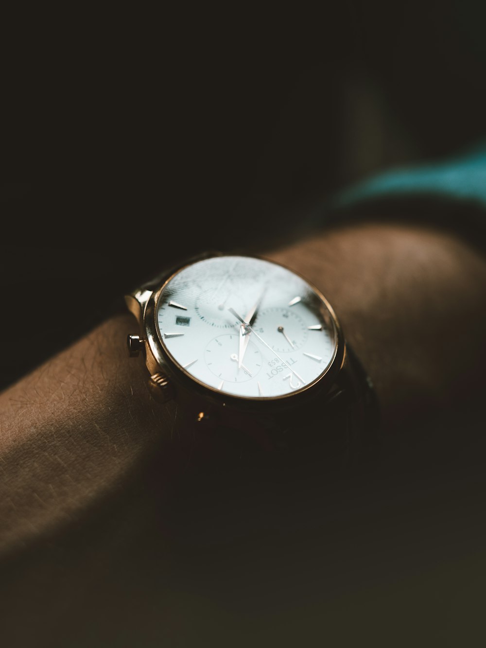 personne portant une montre chronographe blanche