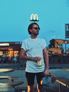 man holding McDonald cup beside camping table