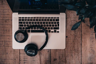 black cordless Bluetooth headphones on top of MacBook Pro