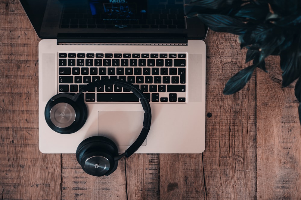 black cordless Bluetooth headphones on top of MacBook Pro